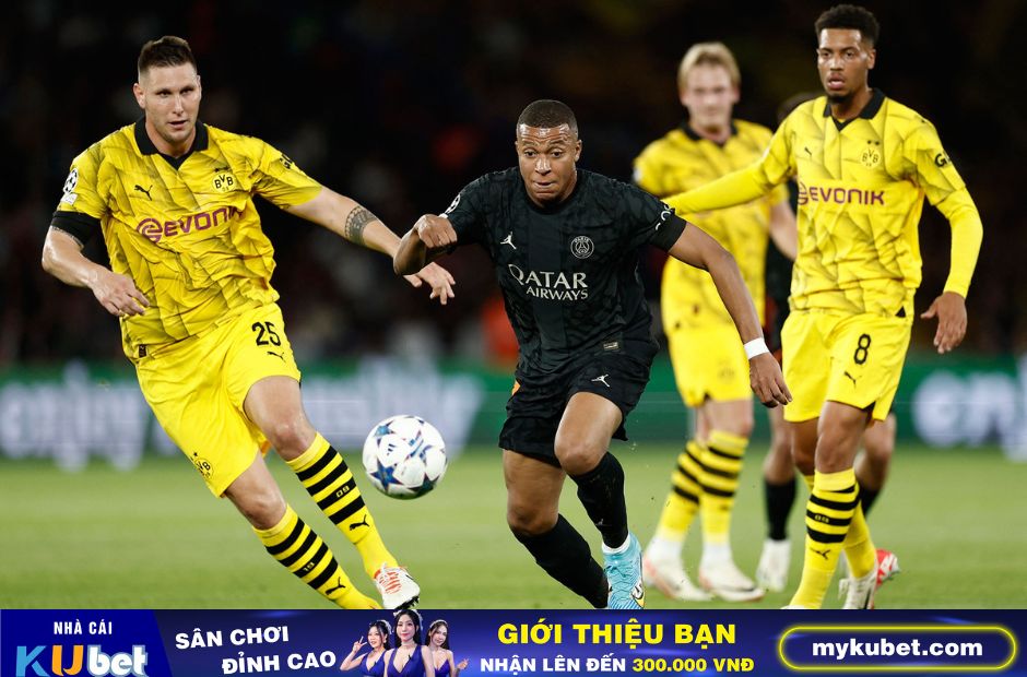 Kubet cập nhật hình ảnh các cầu thủ Dortmund trong trang phục thi đấu màu vàng truyền thống đang ngăn chặn pha đi bóng của Mbappe (quần áo đen) bên phía PSG 